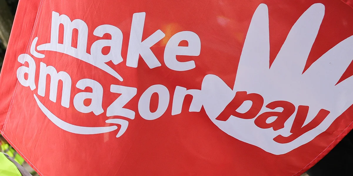 "Make Amazon Pay"-Protest hëlt dëst Joer och de Premier Luc Frieden an d'Viséier | © picture alliance/dpa | Christian Charisius